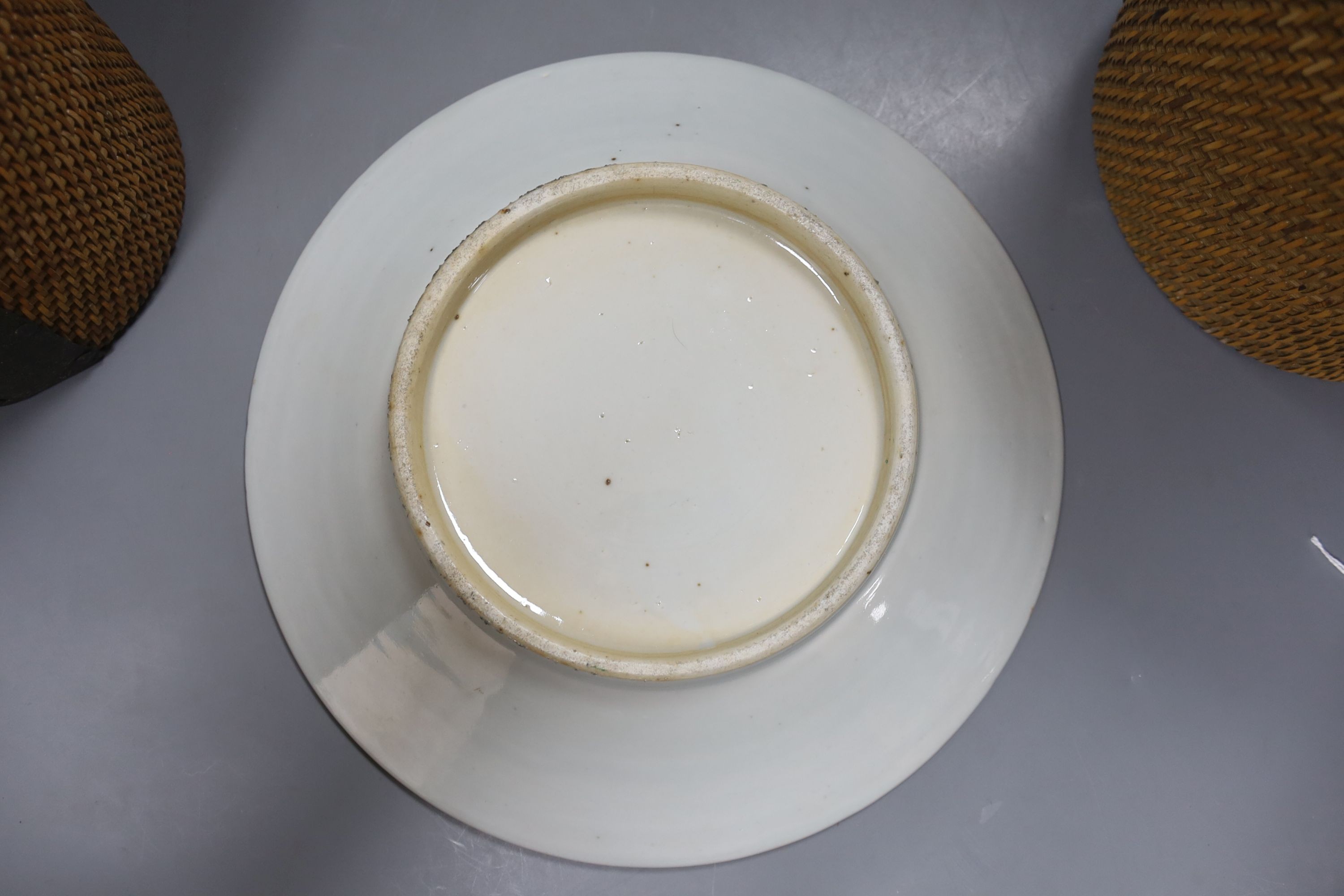 Three late 19th/early 20th century Chinese famille teapots, two in baskets and a similar dish, dish 29.5 cms diameter.